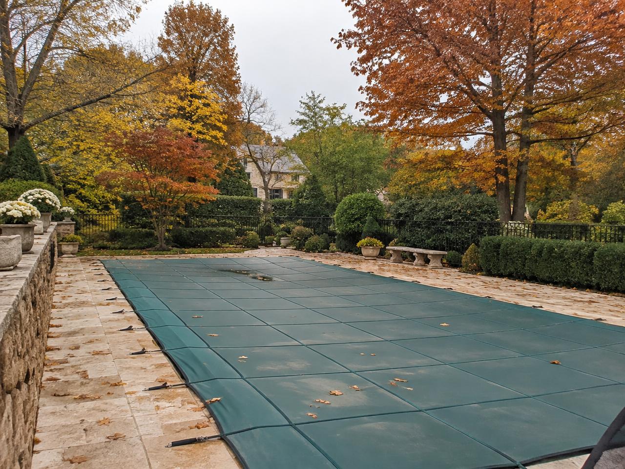 Piscine couverte d'une bâche d'hivernage en automne (illustration)